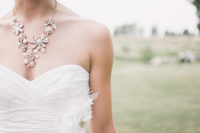bridal accessory flatlay with delicate earrings hair pins and soft beige fabric